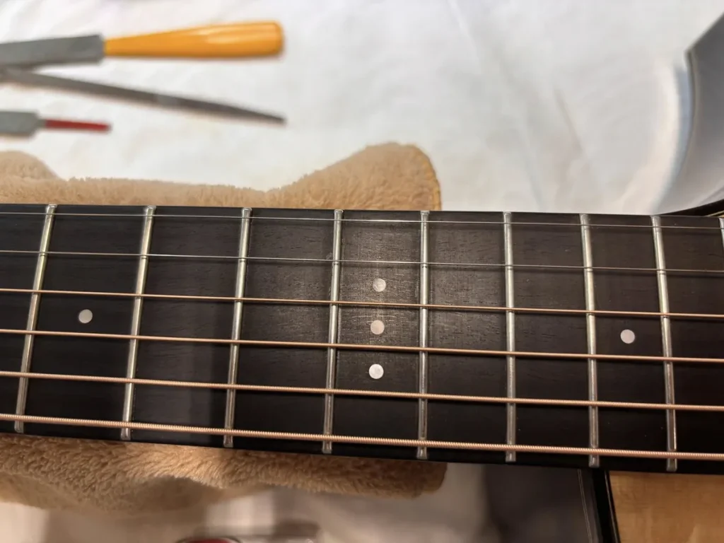 Dettaglio della lavorazione manuale del manico di una chitarra acustica nel laboratorio di Carlo Corsalini